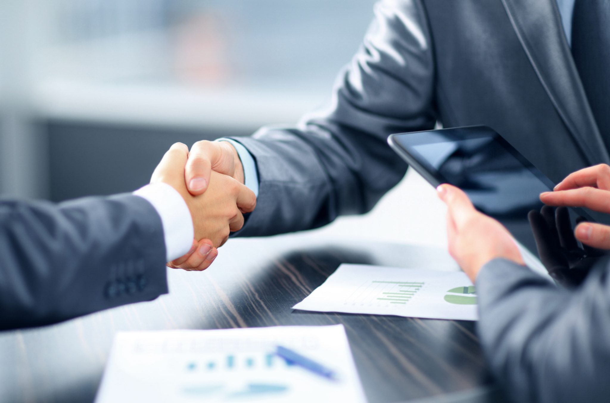 Two advisors reviewing transaction documents across a table